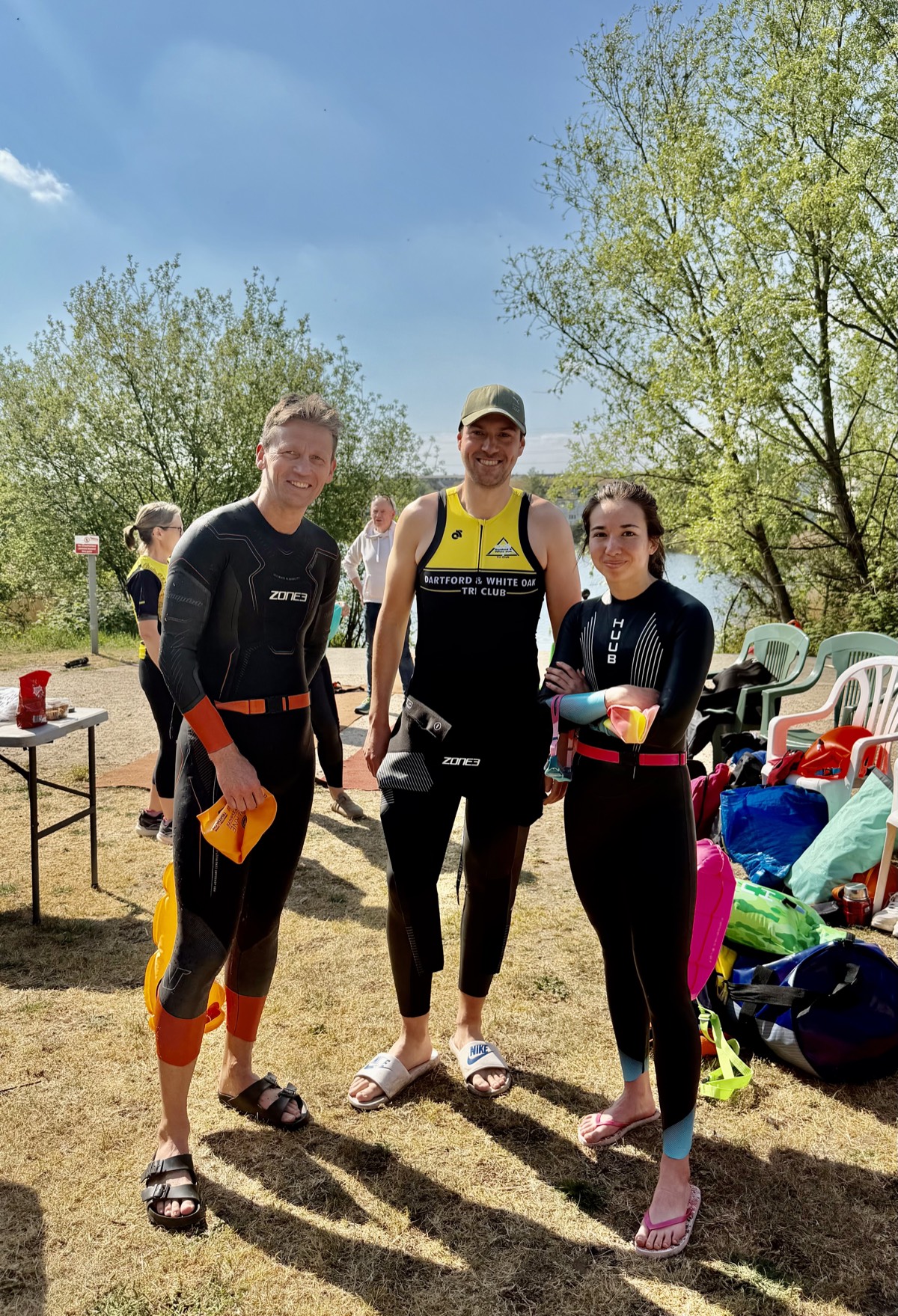 Club members in wetsuits open-water swimming at the lake