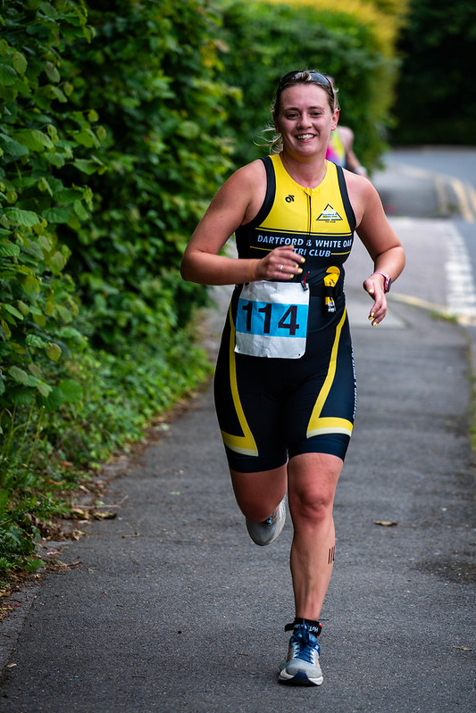Club runner smiling mid-race